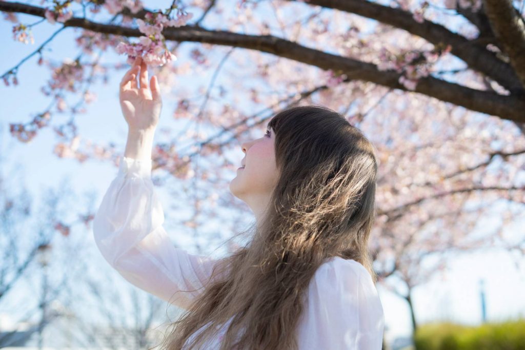 woman touching cherry blossom