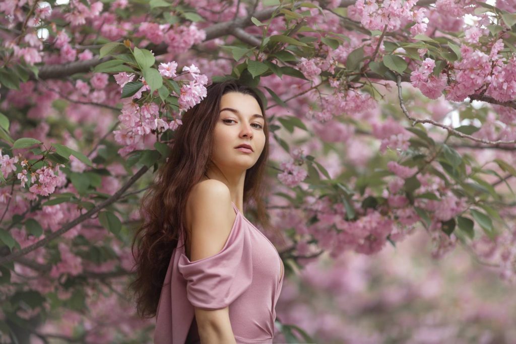 woman pose with cherry blossom behind her back