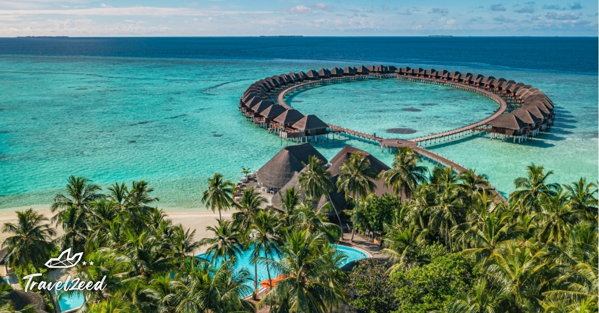 ภาพมุมสูงรีสอร์ทมัลดีฟส์พร้อมวิลล่าน้ำกลางทะเลสีฟ้าใส เหมาะสำหรับแพ็กเกจทัวร์มัลดีฟส์สุดหรู